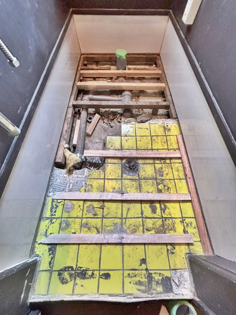 1日目は既存の便器を撤去し、床材を剥がす作業を行いました。床材を剥がすと、もともと使用されていたタイルが現れました。
