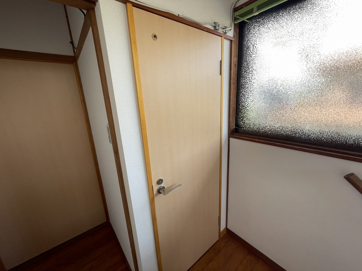 廊下から見た新設トイレの入口、両面プリント合板フラッシュ建具