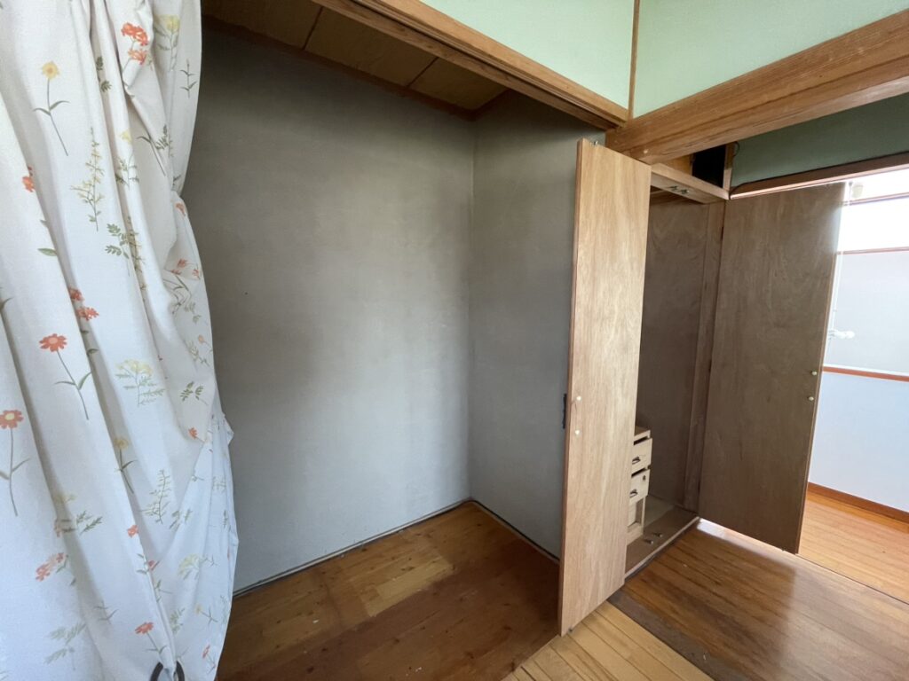 花柄のカーテンが掛けられ、壁は緑色のクロス仕上げ。